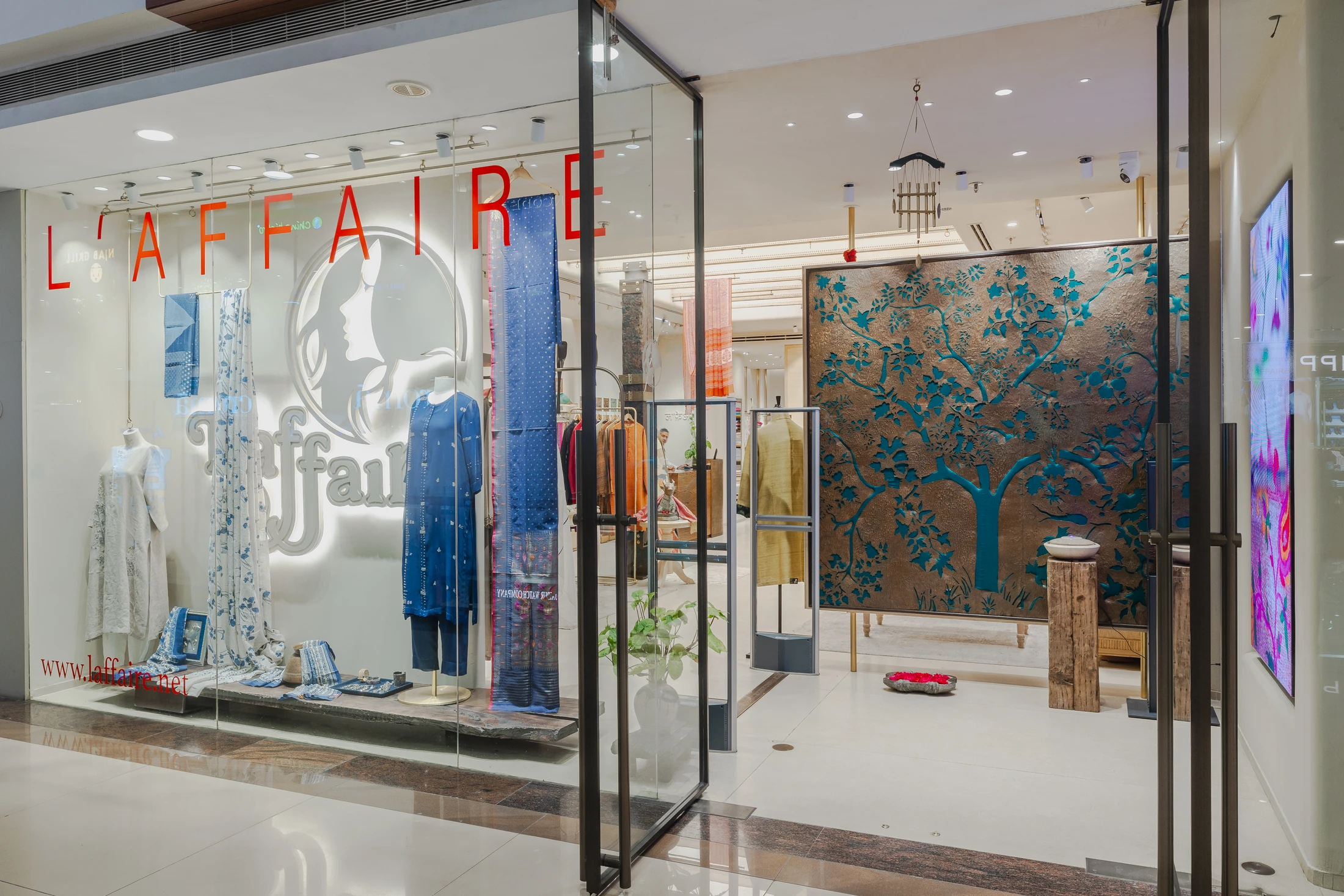 The L’affaire shopfront at Select Citywalk: the L’affaire name and logo on the glass, the tree of life inside